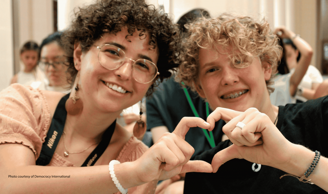 Photo of 2 young people shaping heart with their hands