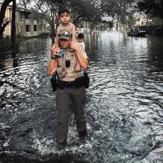 A Florida Fish and Wildlife officer helps to evacuate a flooded Florida neighborhood in the aftermath of Hurricane Milton on October 10, 2024. Florida Fish and Wildlife photo from their Flickr account. Image has been cropped and brightened. Used under a Creative Commons license.