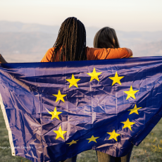 Image of two people holding an EU flag